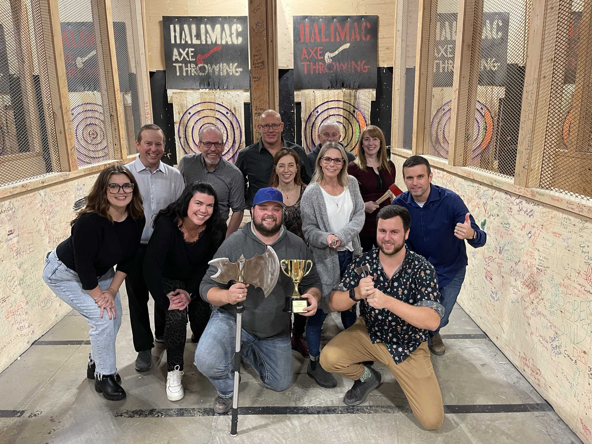 FSC board of directors hold up axe throwing trophy.